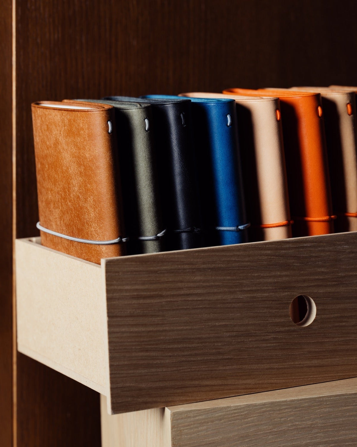 Finished leather notebook covers standing in a wooden drawer