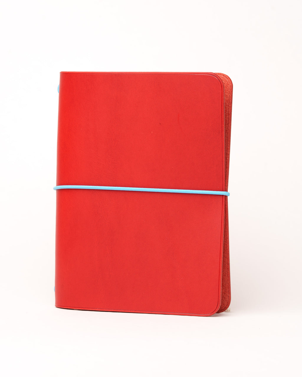 Red Buttero Leather Cover, angled view showing the fore-edge and elastic, on white